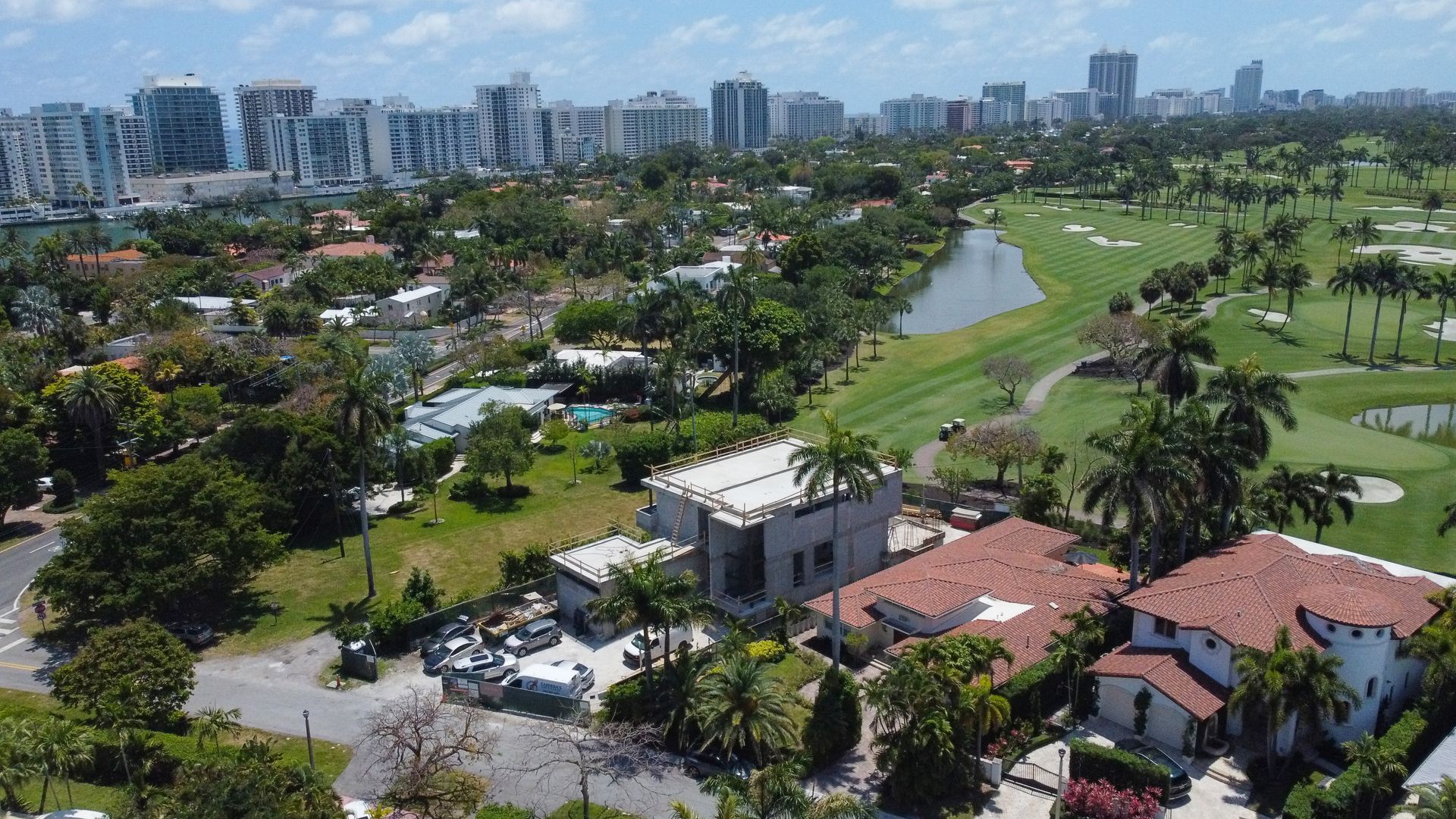 An aerial view of a golf course with a city in the background
