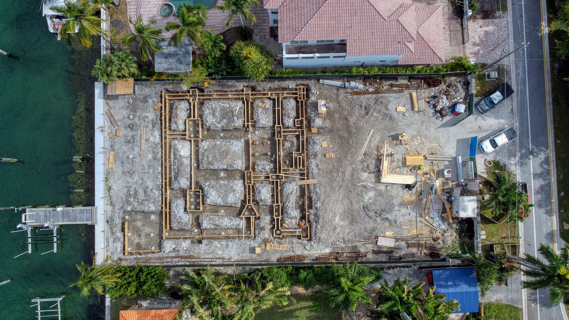 An aerial view of a building under construction next to a body of water.