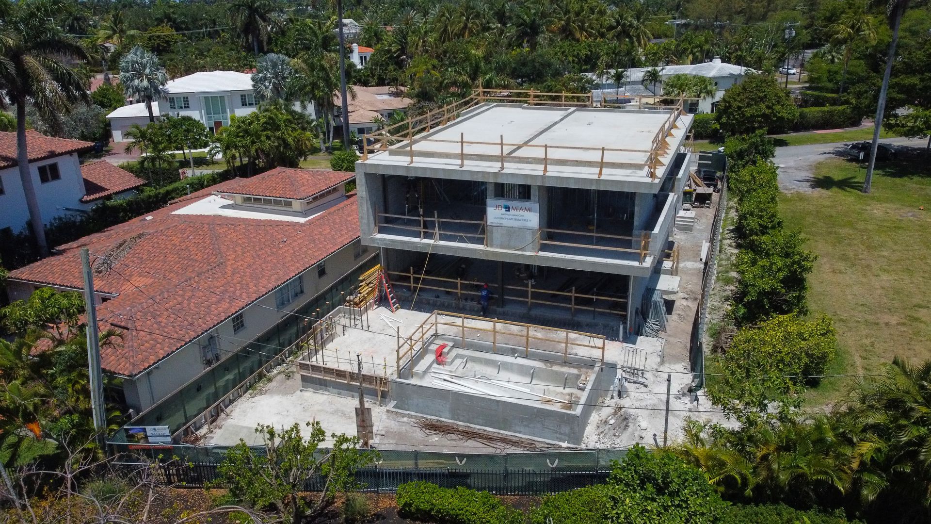 An aerial view of a large building under construction in a residential area.