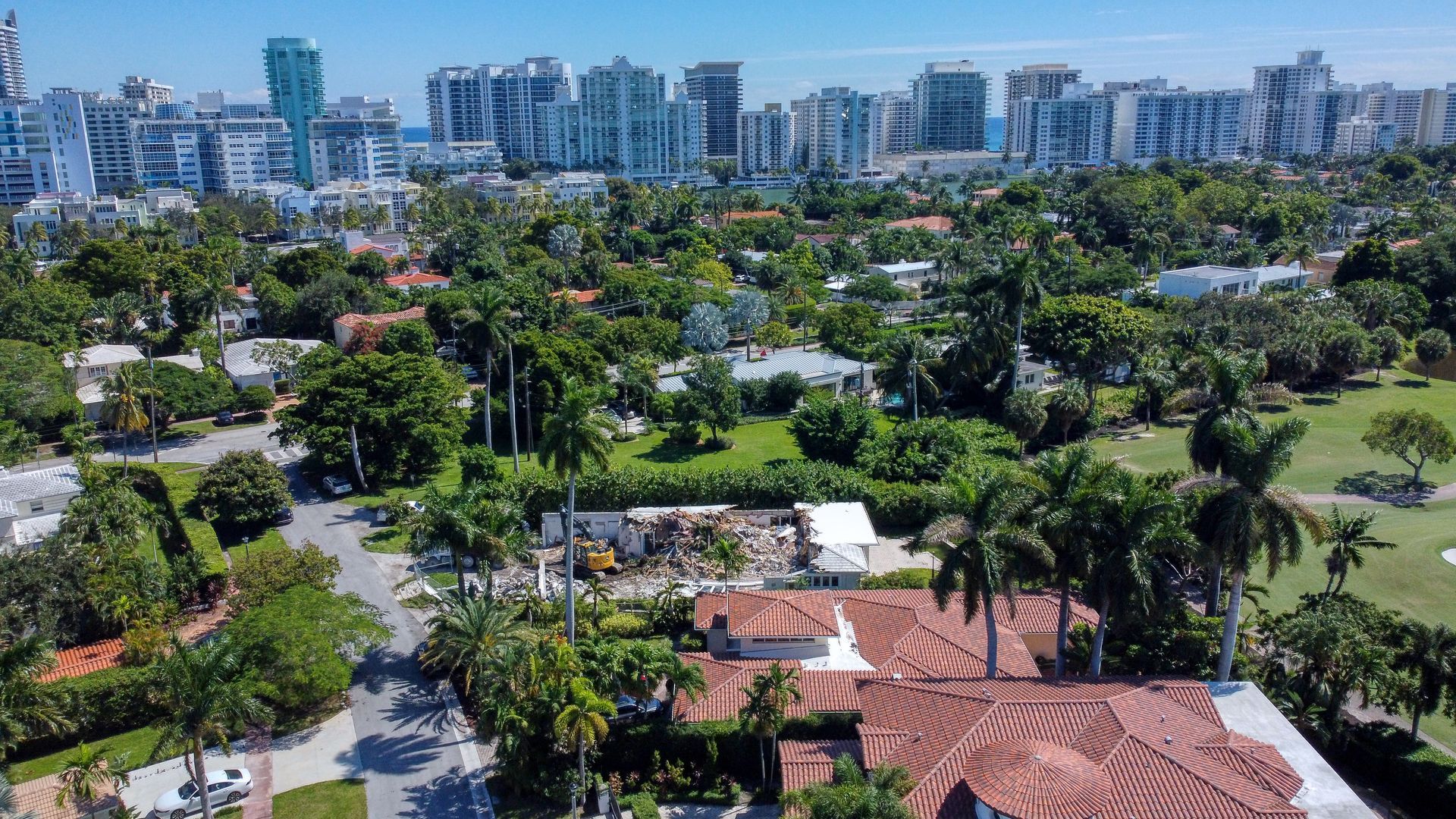 An aerial view of a residential area with a city skyline in the background.