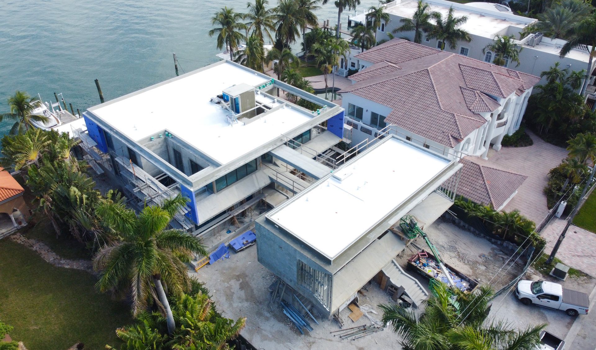 An aerial view of a house under construction next to a body of water