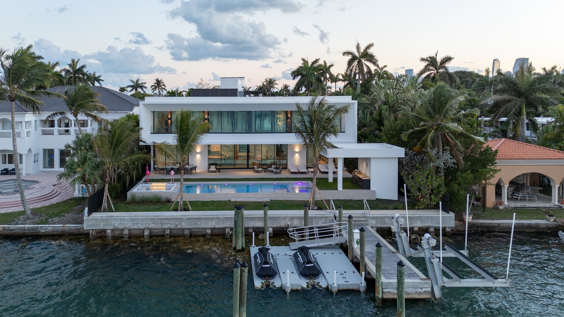 Modern waterfront home with pool and dock.