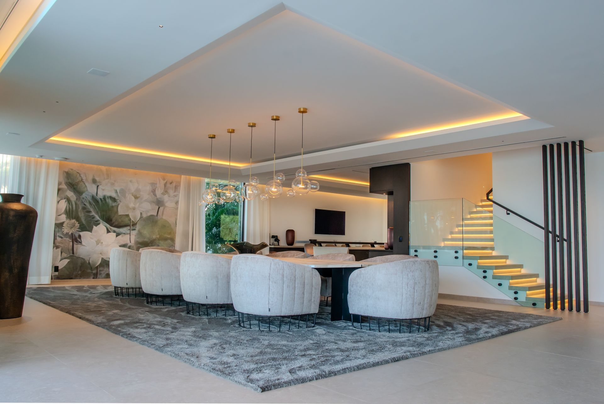 Elegant dining room with large table, white chairs, and modern light fixtures.