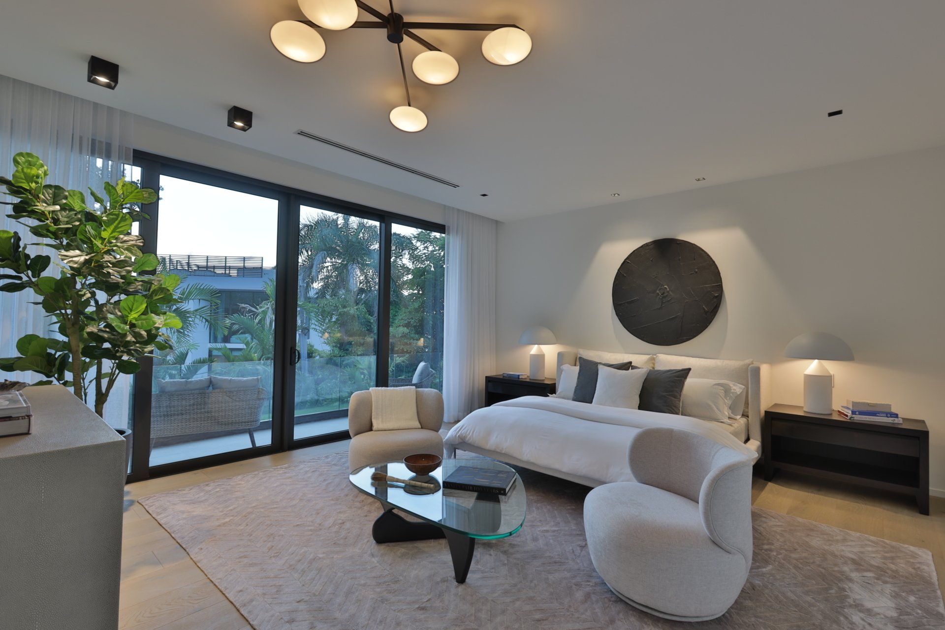 A bedroom with a large bed , chairs and a coffee table