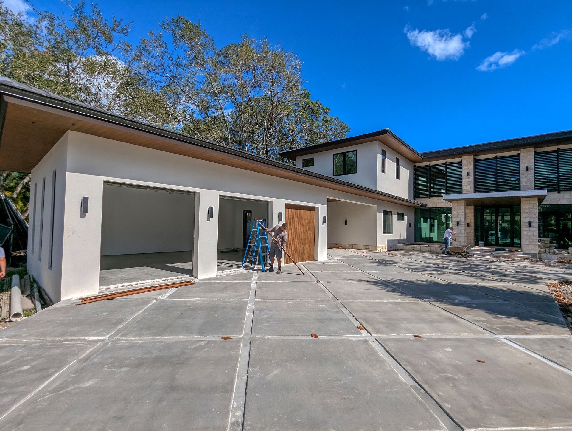 Two-story house with attached garage under construction; concrete driveway.