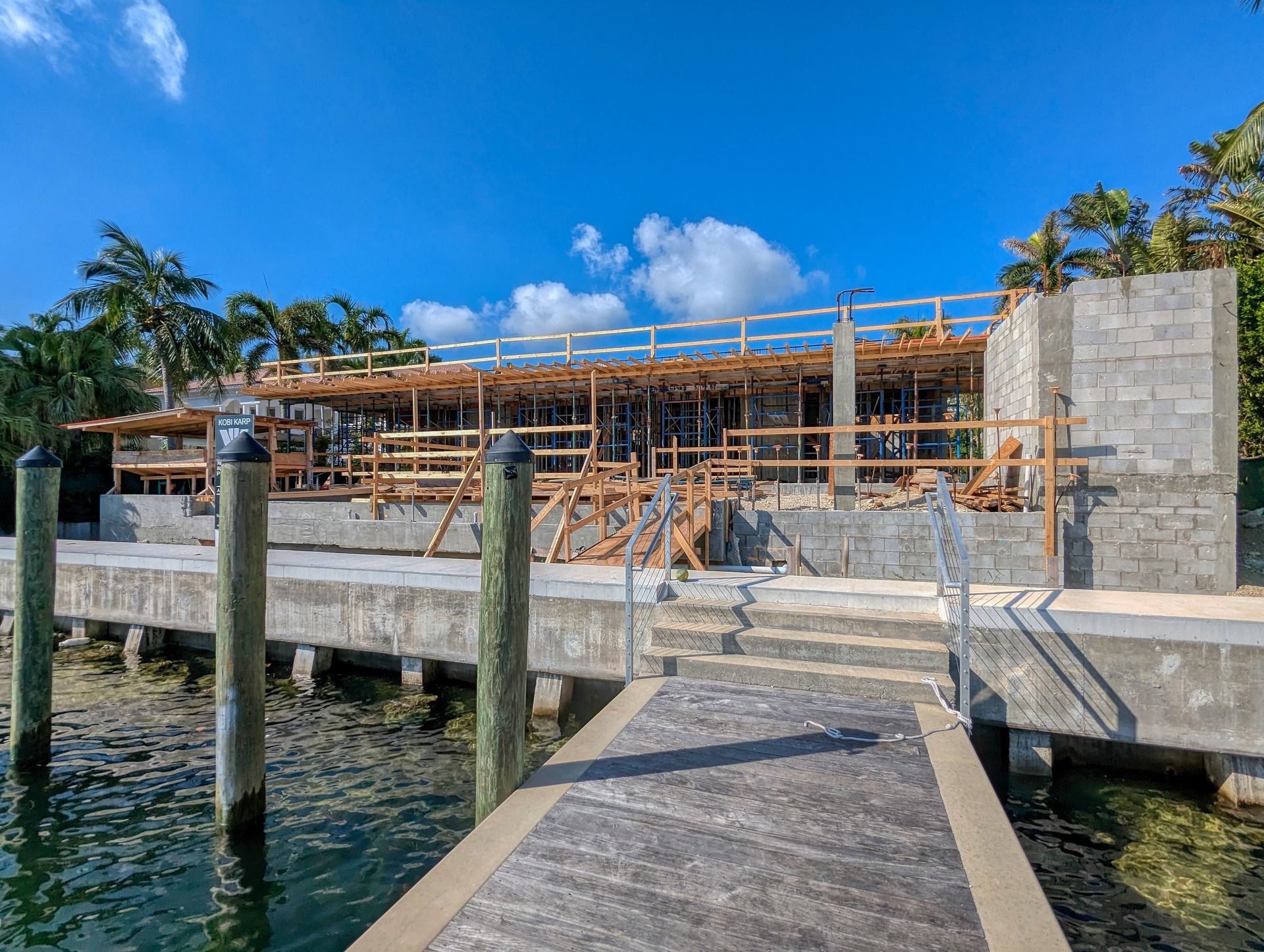 A dock leading to a building under construction next to a body of water.
