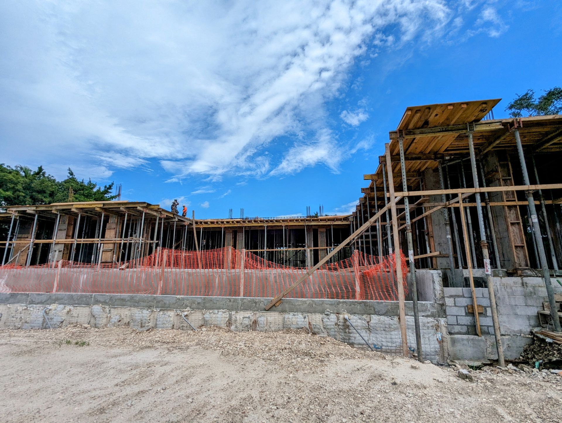 Construction site with wood scaffolding under a blue sky.
