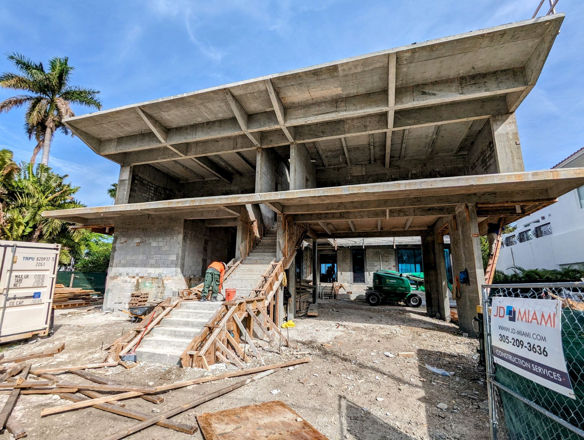 A large building is being built in the middle of a dirt field.