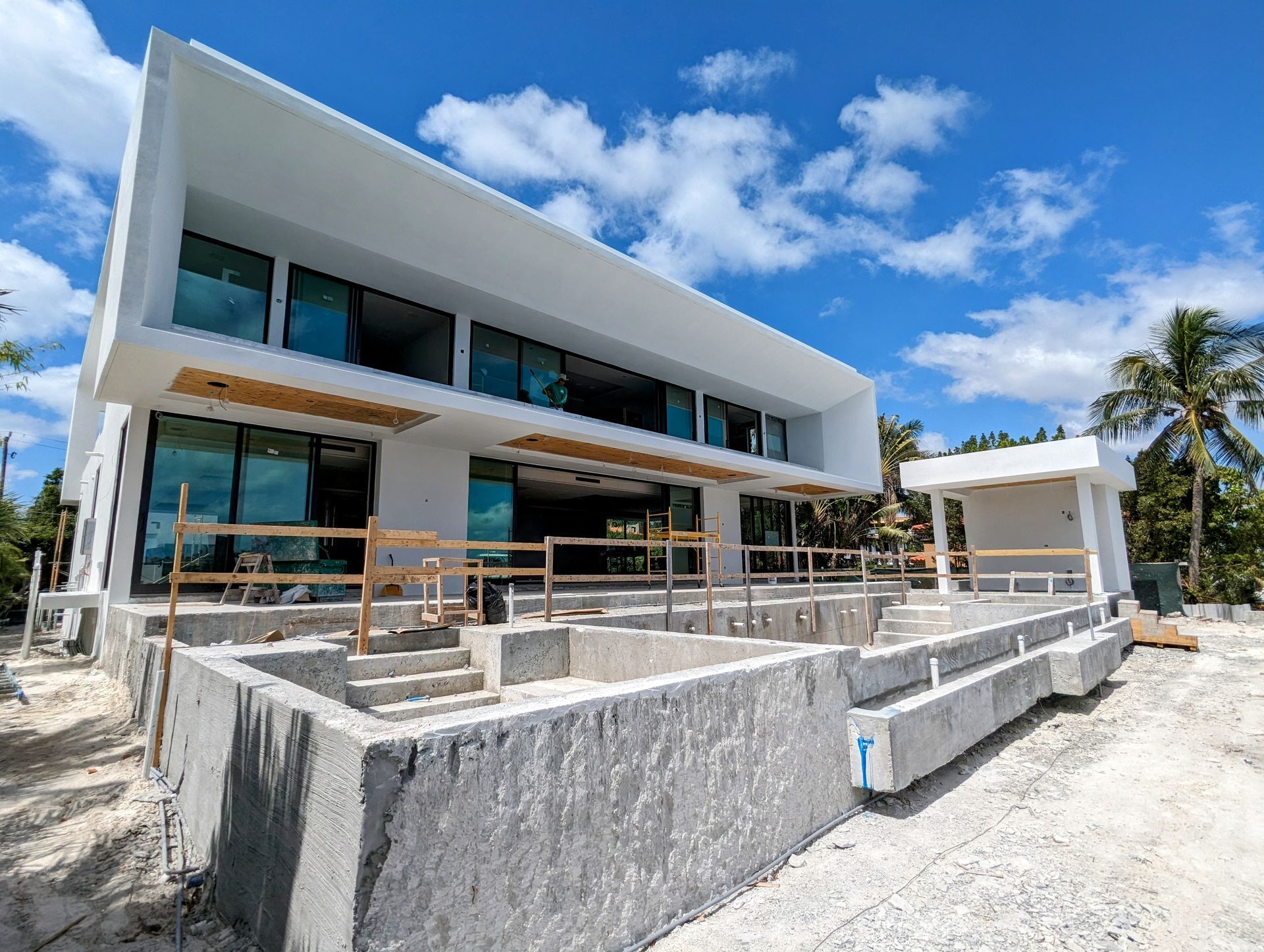 A large white house is being built on a beach.