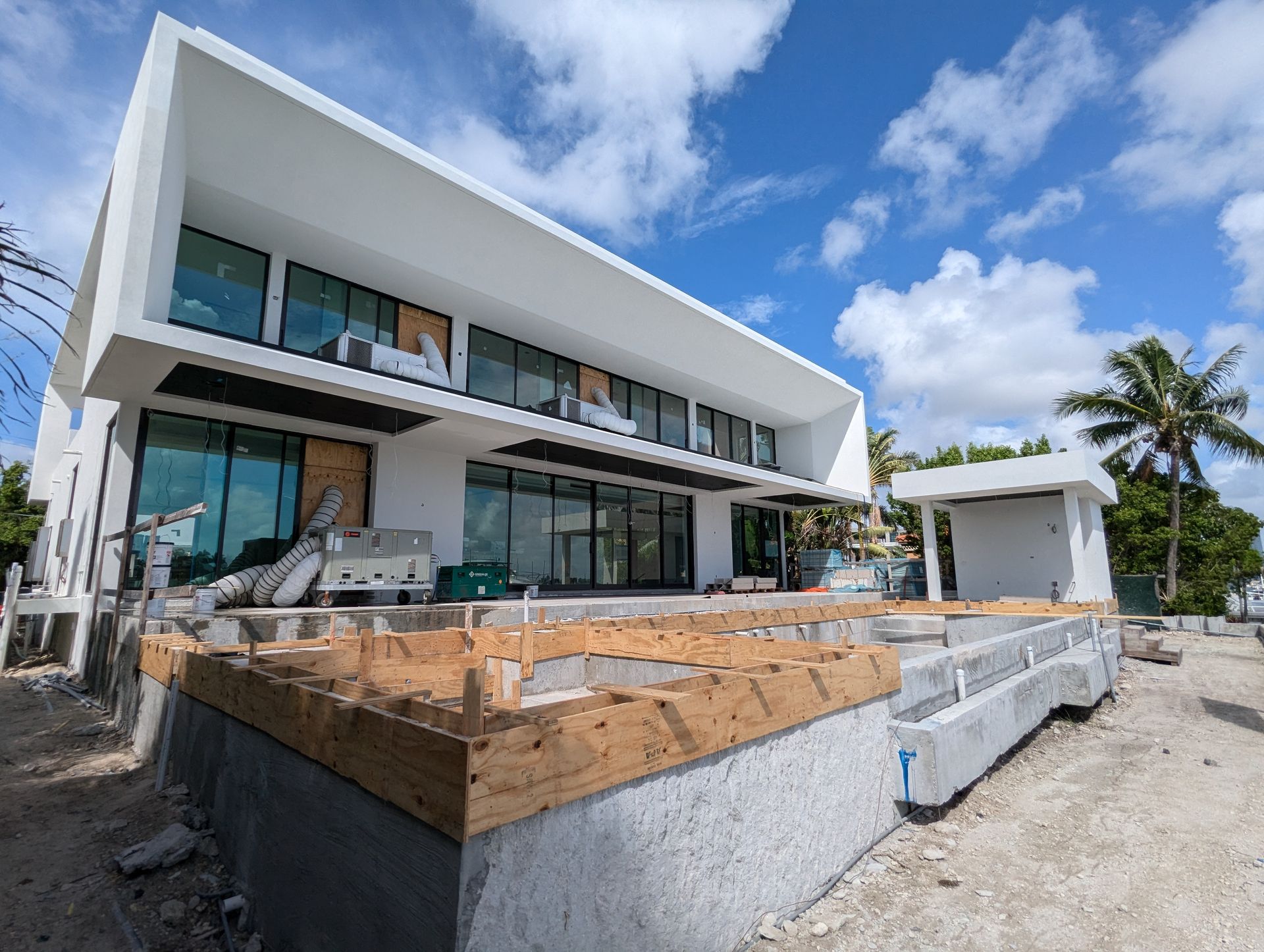 A large white house is being built on a hill.