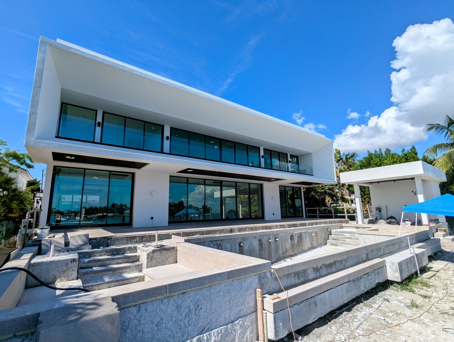 A large white house with a swimming pool under construction