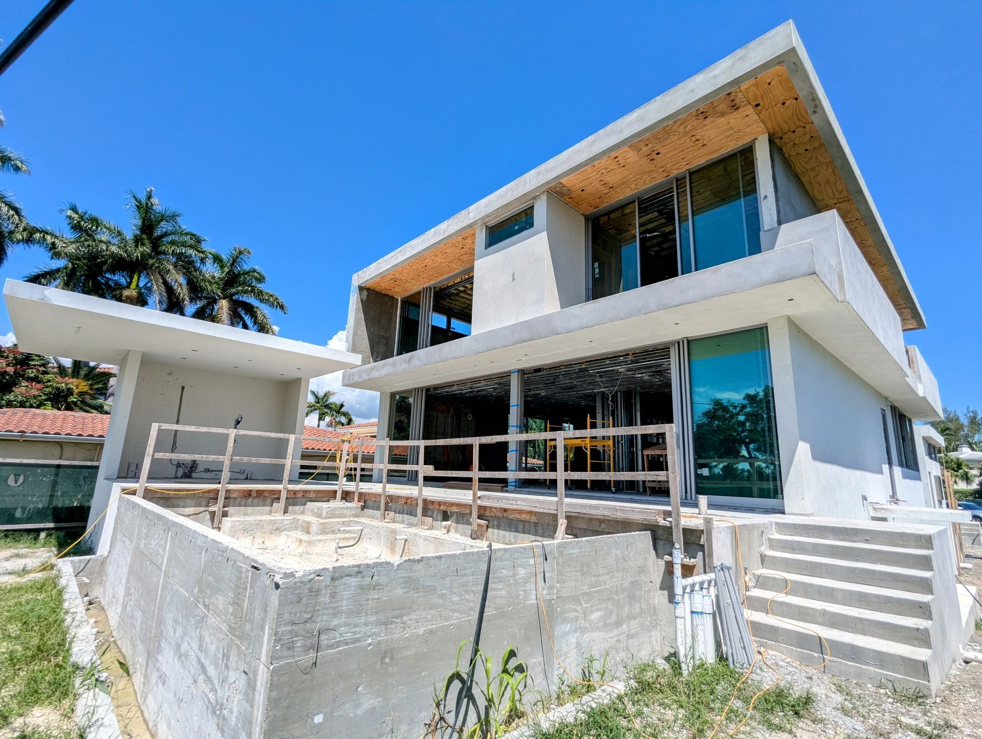 A large white house is being built on a hill.