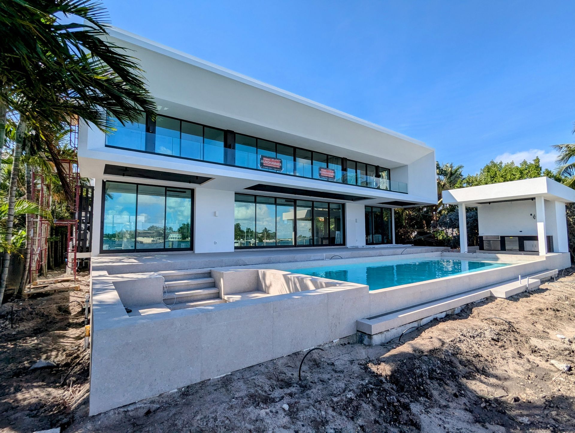 A large white house with a swimming pool in front of it