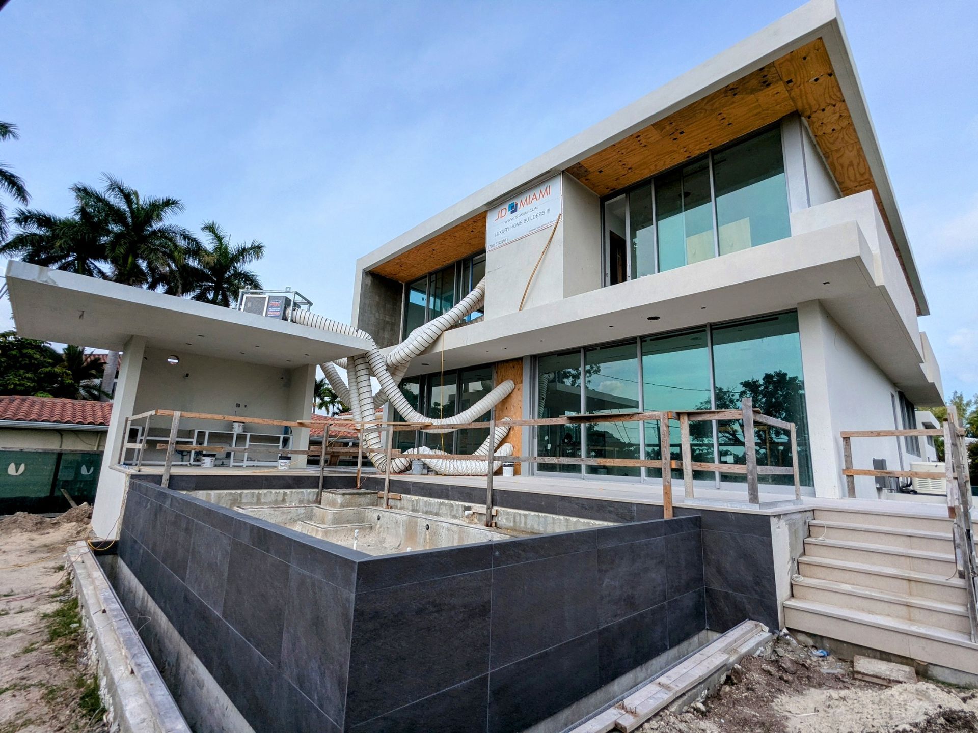 A large white house with a lot of windows is being built.