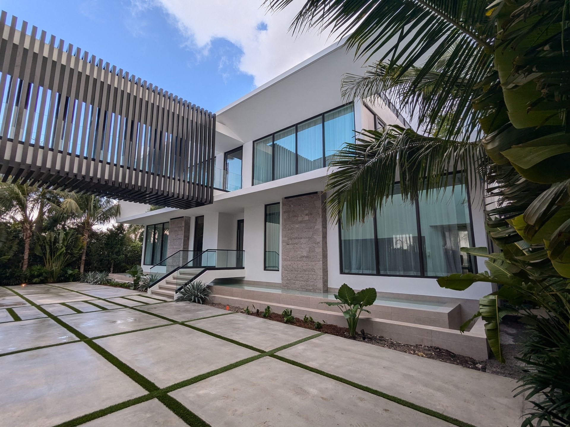 A large white house with a lot of windows and a large driveway.