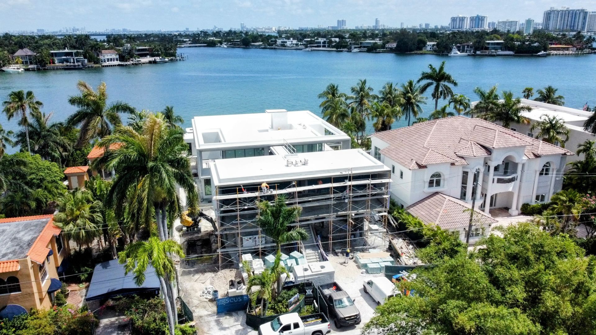 An aerial view of a house under construction next to a body of water.