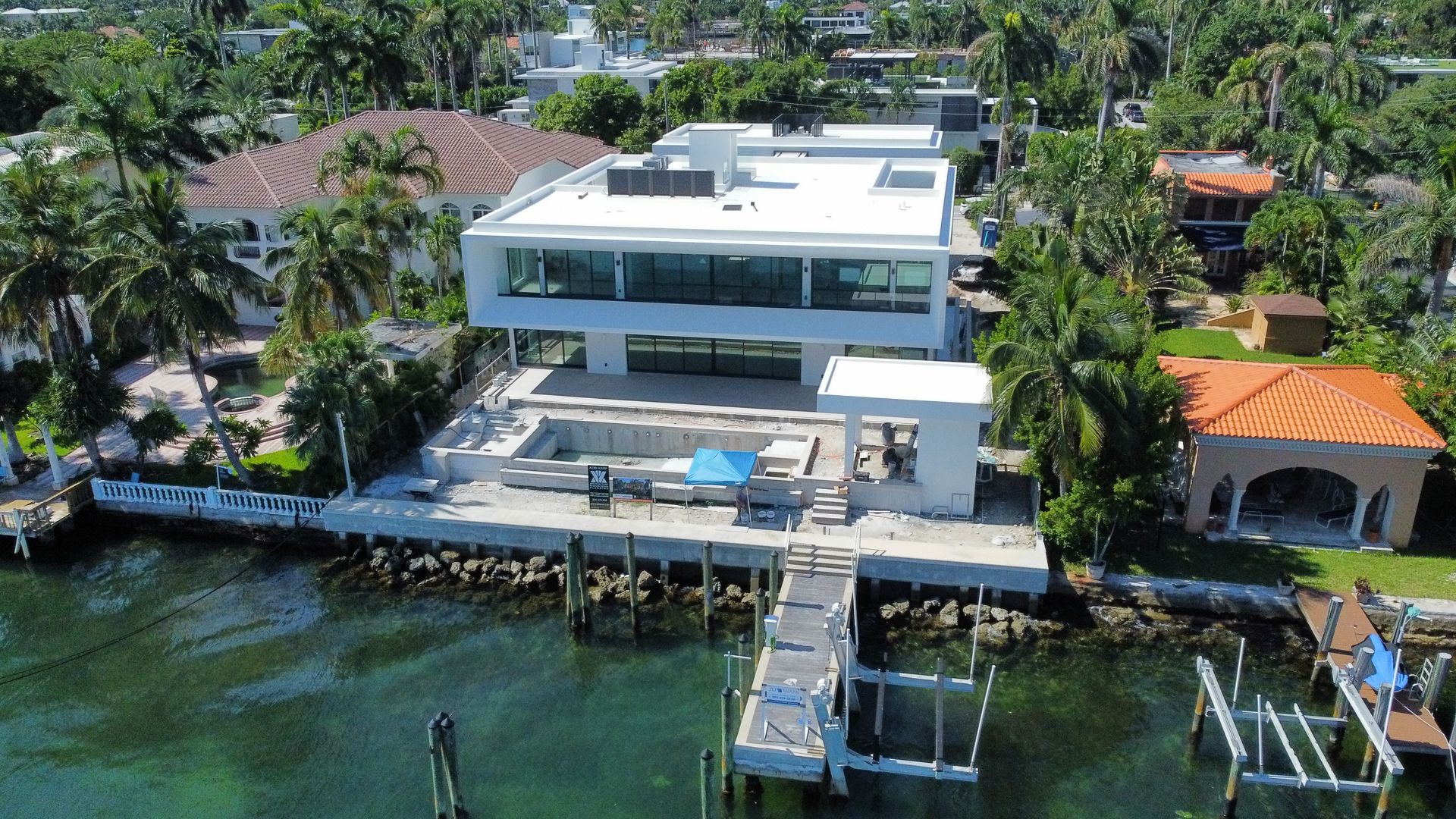 An aerial view of a large house with a dock in front of it