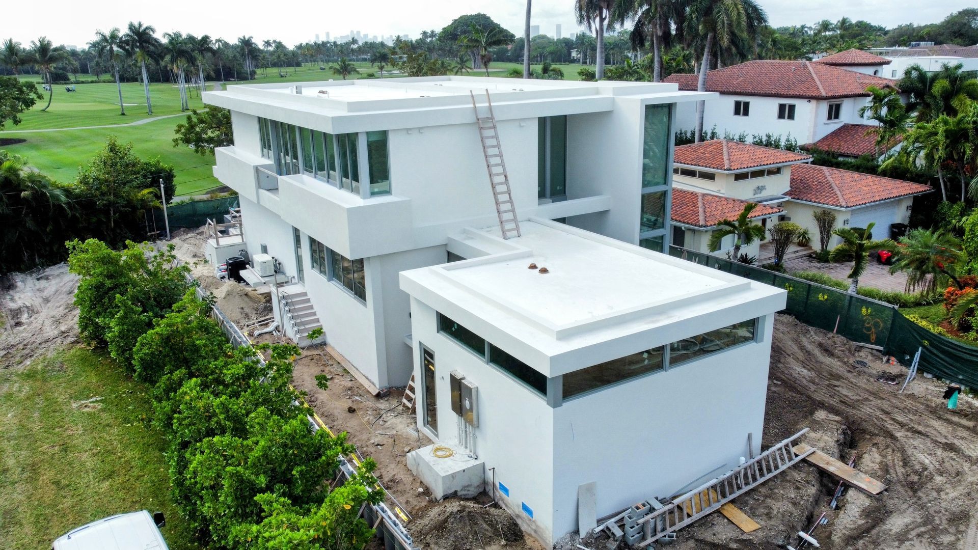 An aerial view of a large white house under construction.
