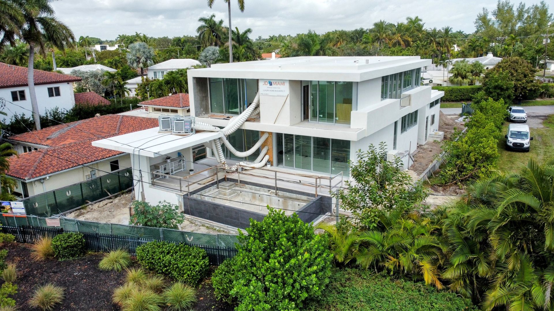 An aerial view of a large white house with a hammock in the backyard.