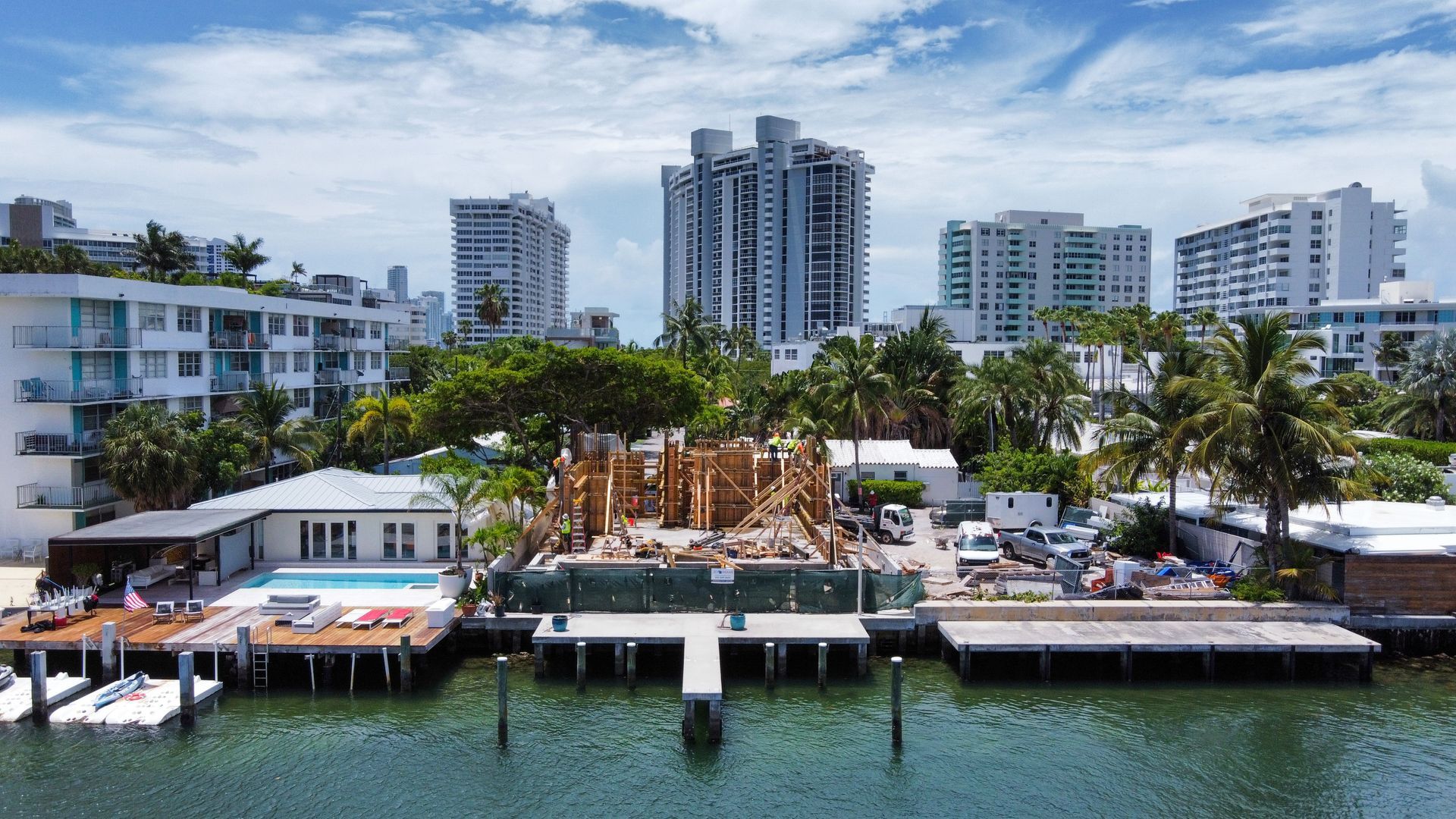Waterfront buildings in a city. Construction site in front. Blue water.