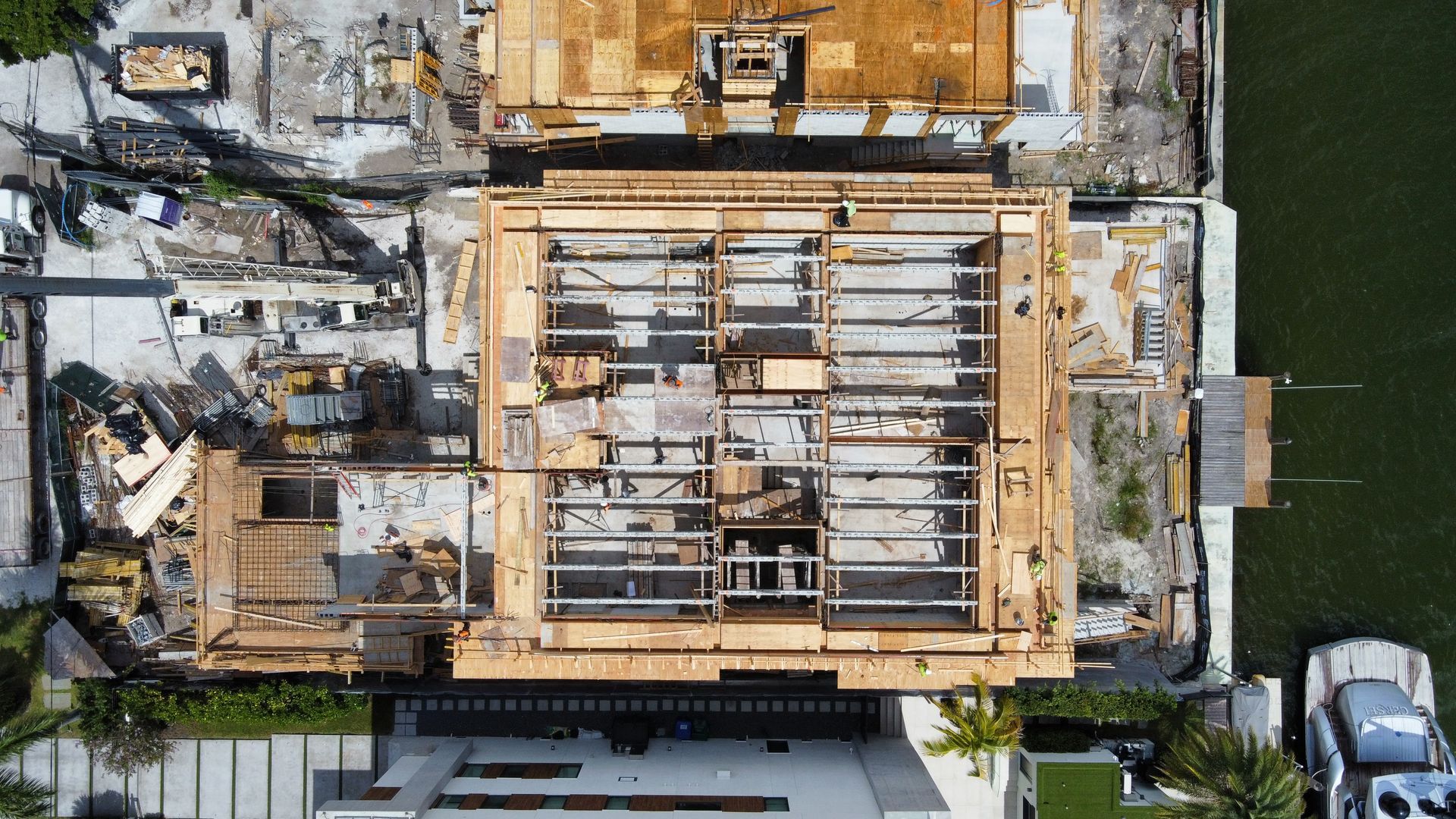 Overhead view of a building under construction, showing wooden framework and materials surrounding it.