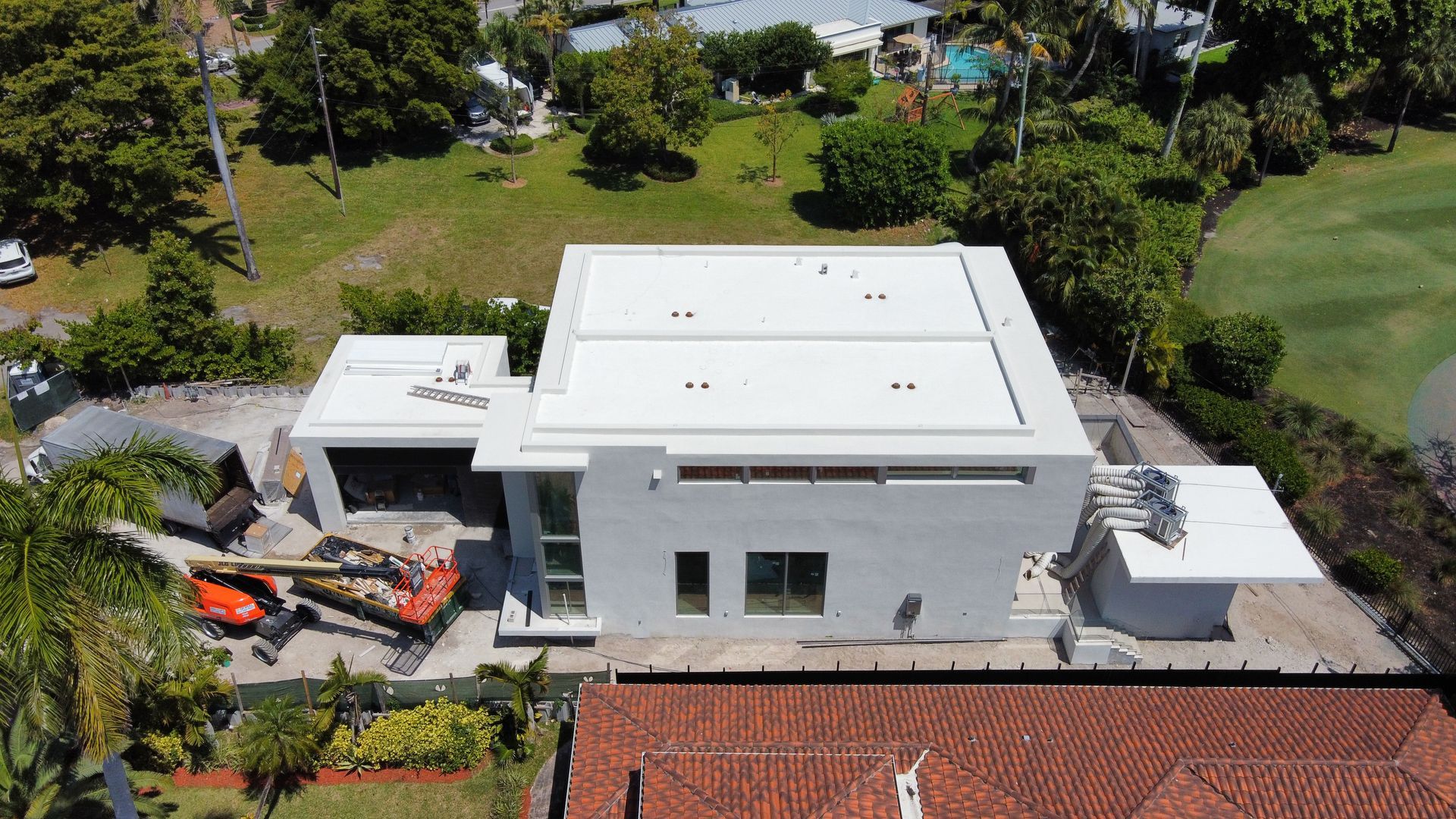 An aerial view of a house under construction with a white roof