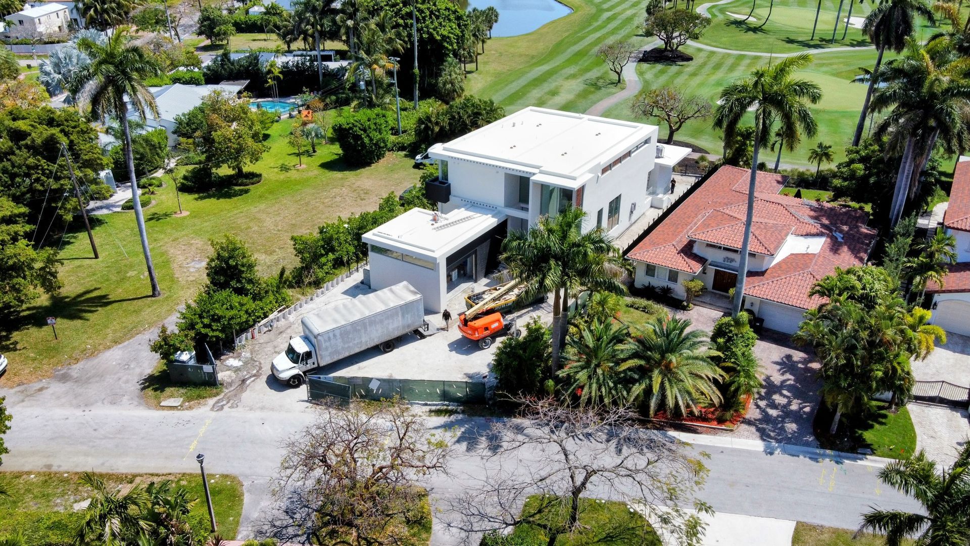An aerial view of a house with a golf course in the background.
