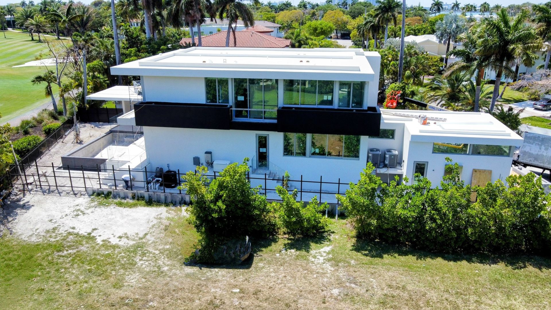 An aerial view of a large white house surrounded by trees.