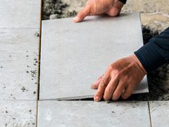 person placing tile on ground
