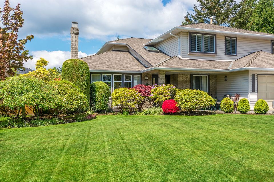 A large house with a lush green lawn in front of it.