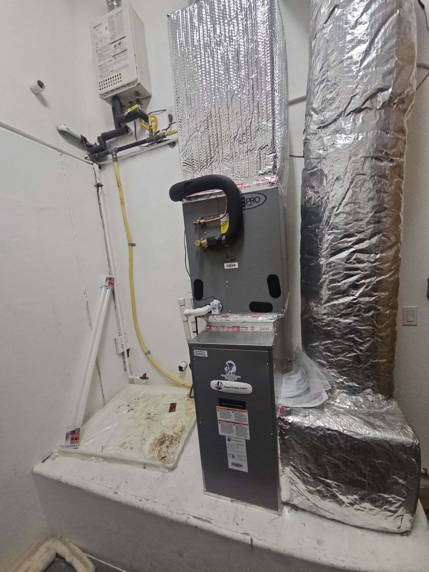 Air conditioning unit with insulated ducts in a utility room.