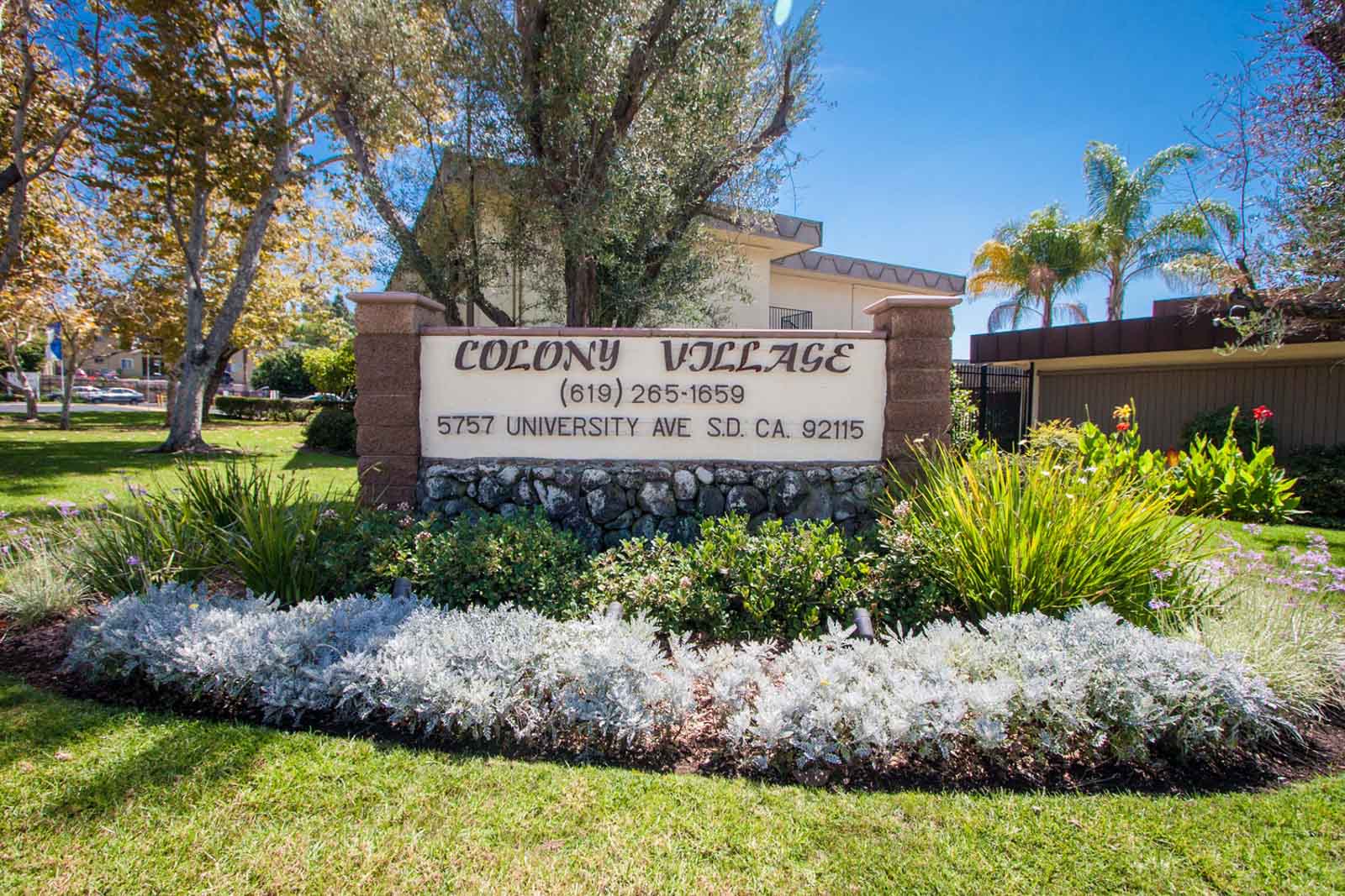 The tan and brown Colony Village sign outside of the community