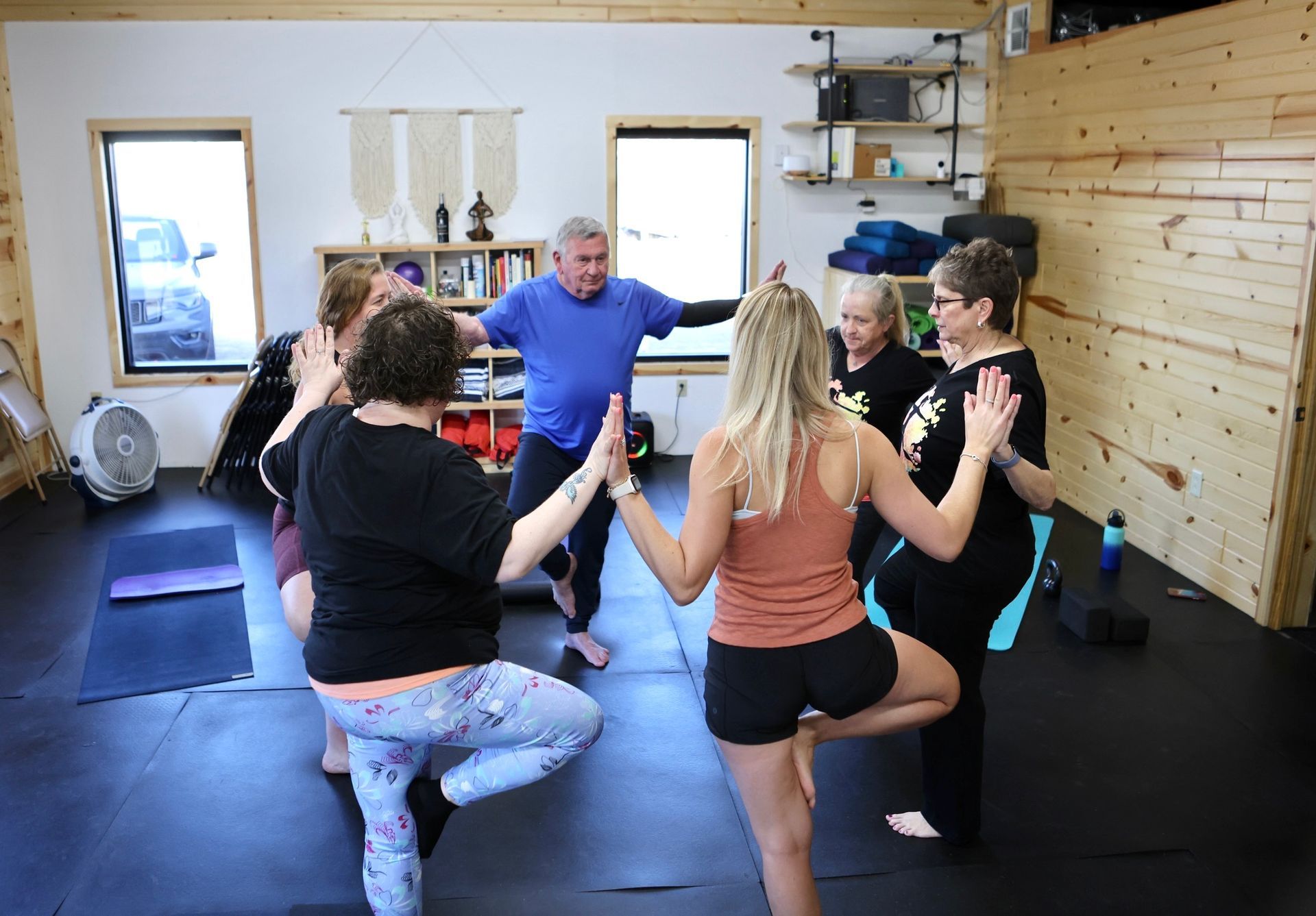 A group of people are doing yoga together in a room.