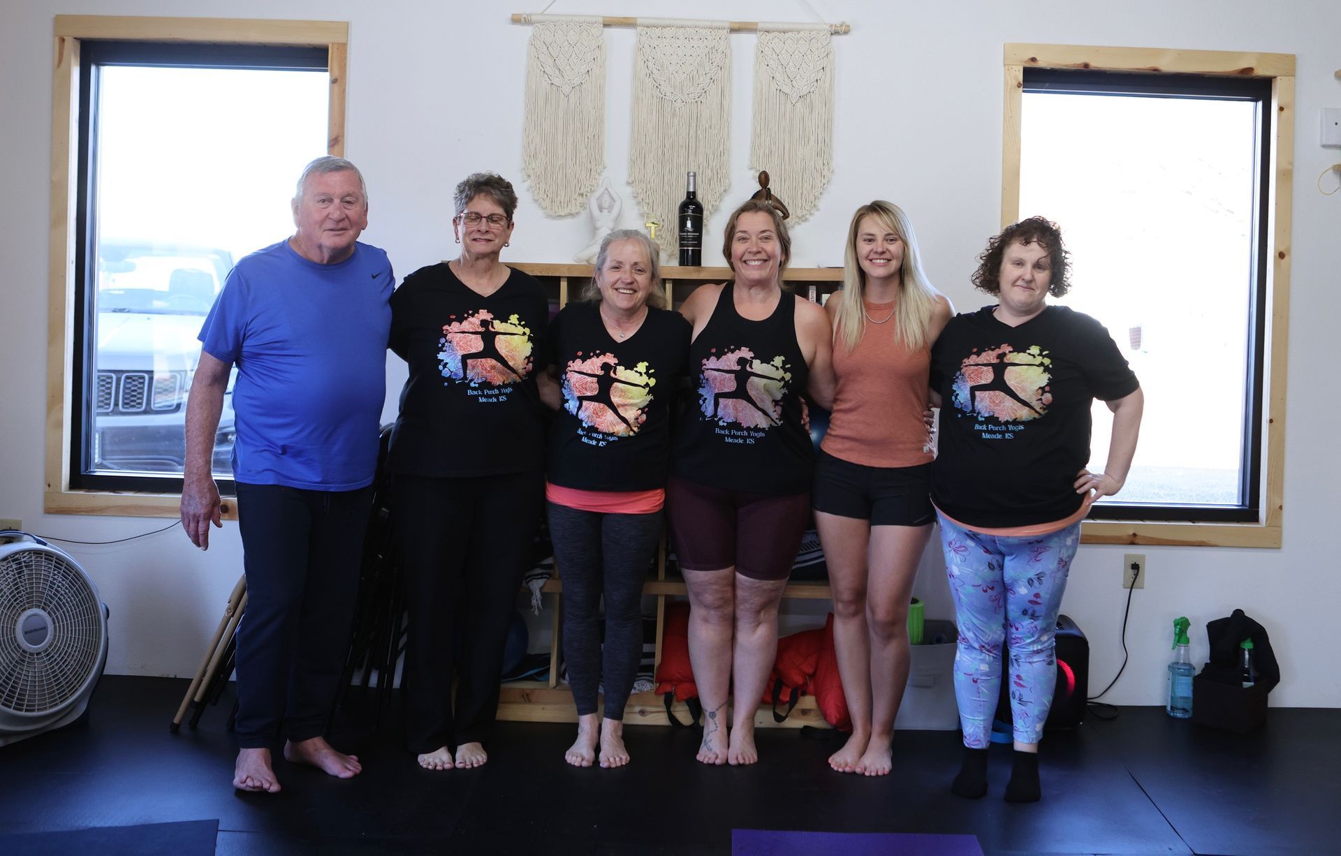 A group of people are posing for a picture in a yoga studio.
