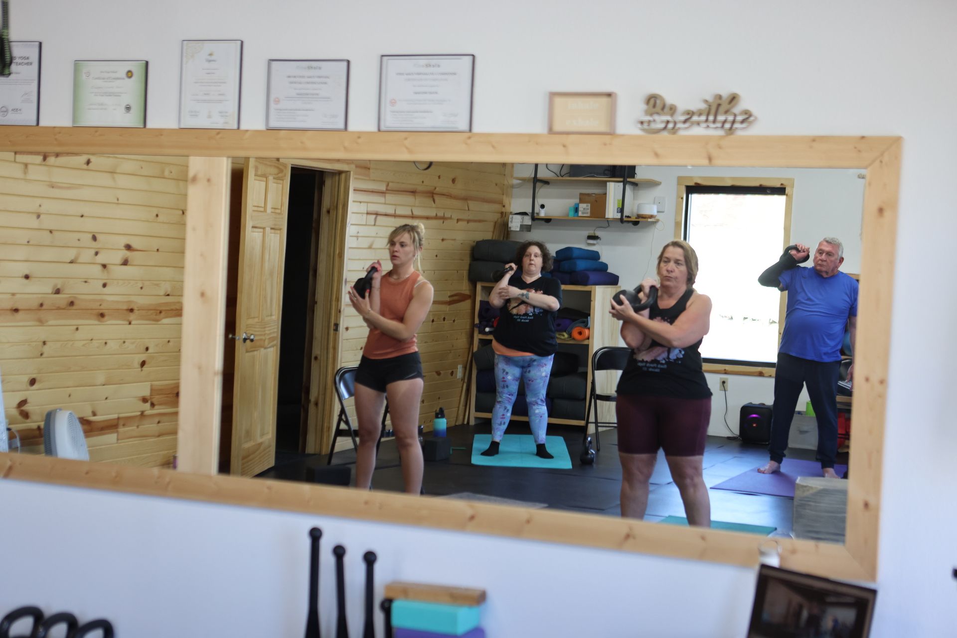 A group of people are standing in front of a large mirror.
