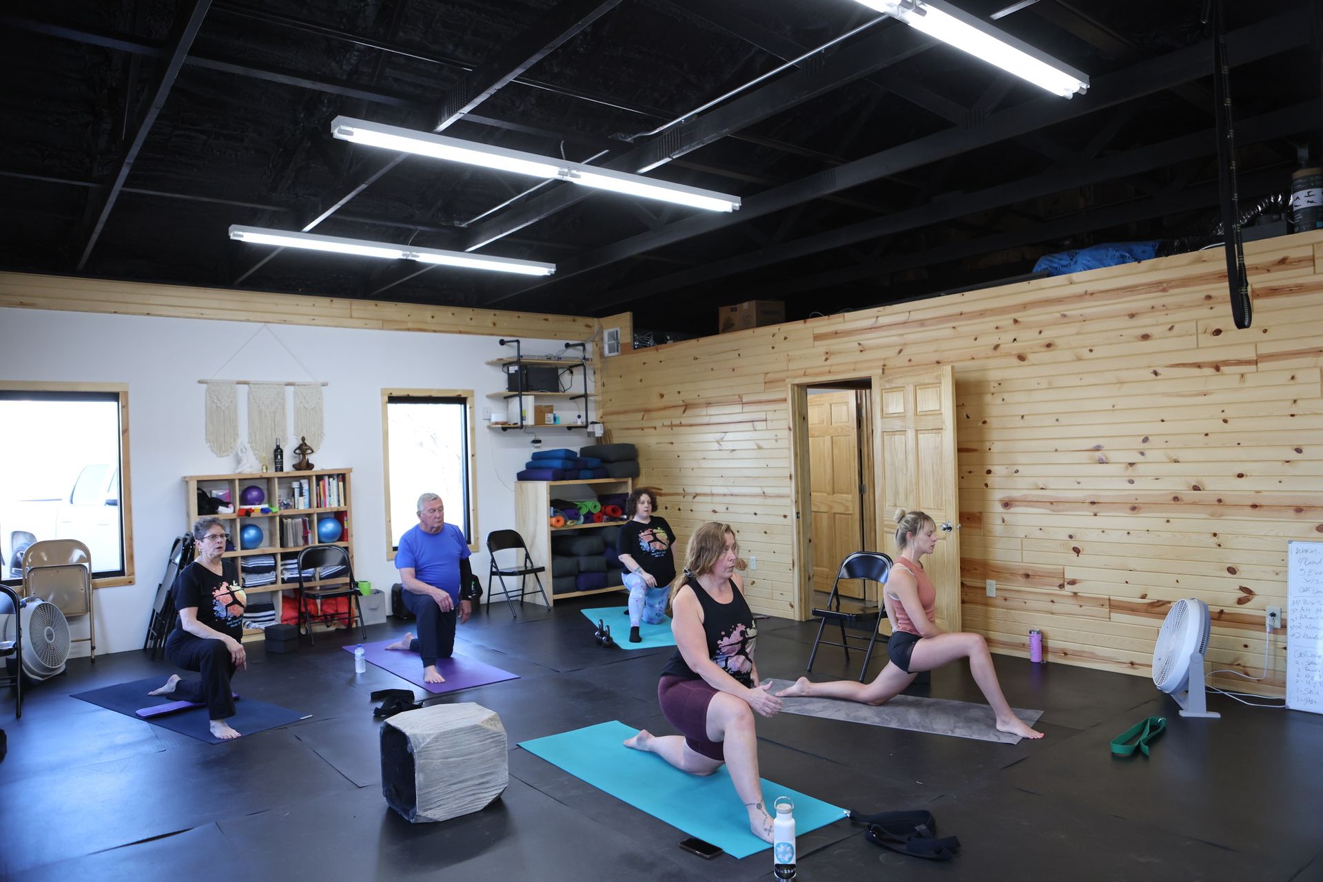 A group of people are sitting on yoga mats in a room.