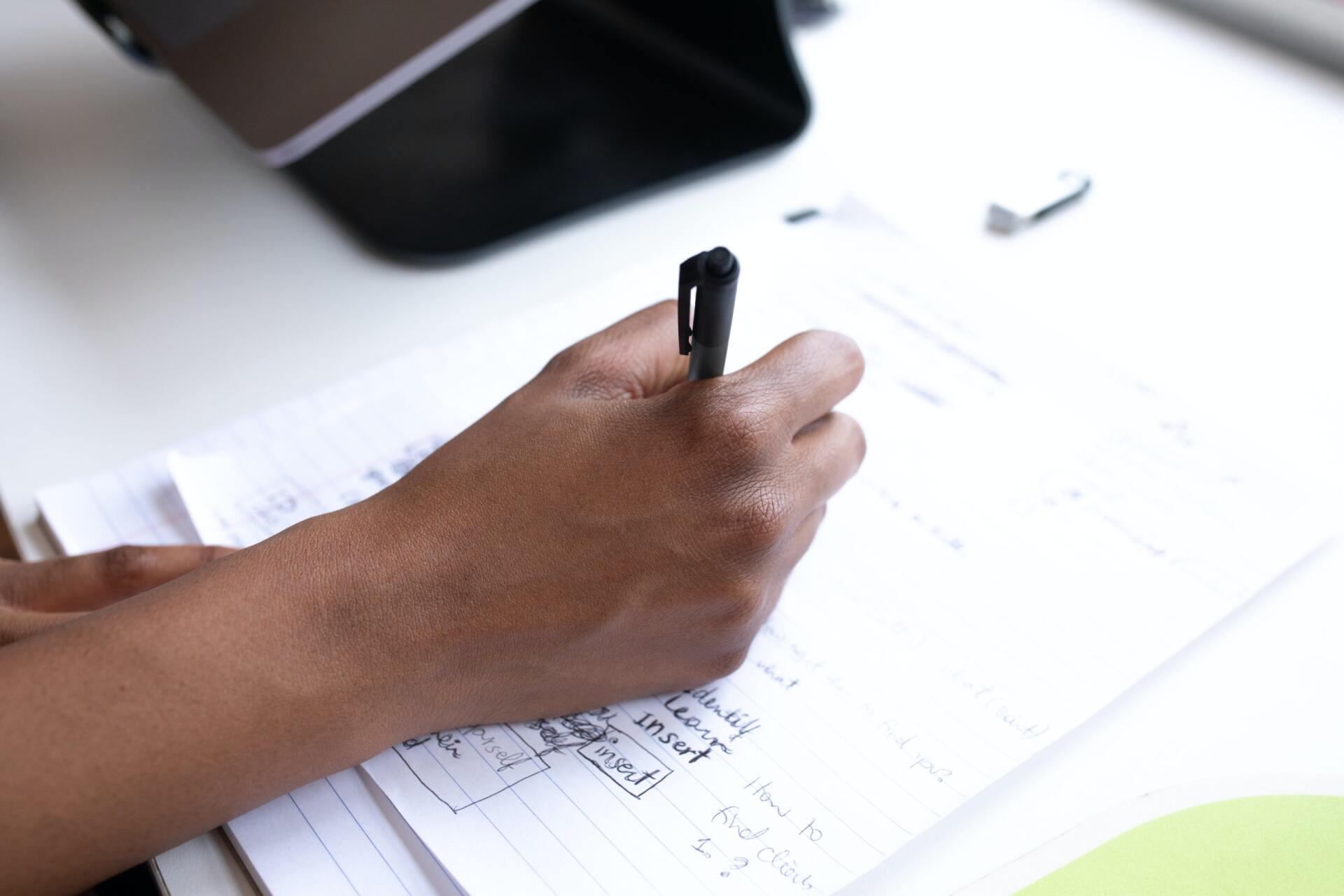 A person is writing on a piece of paper with a pen