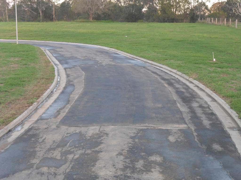 A road that is going through a grassy field