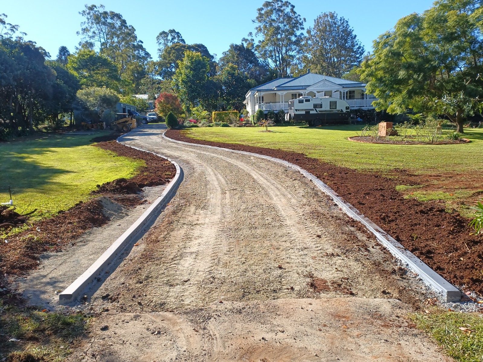 A dirt road with a house in the background