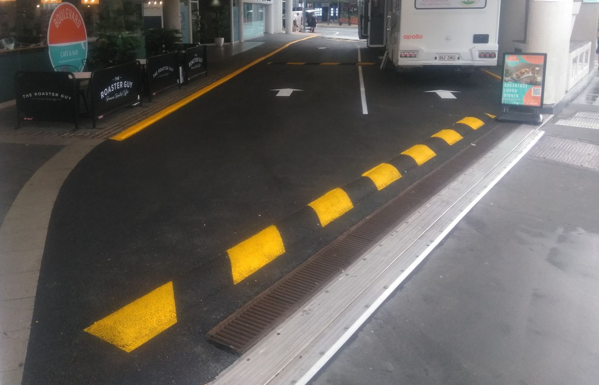 A yellow and black striped barrier on the side of a road