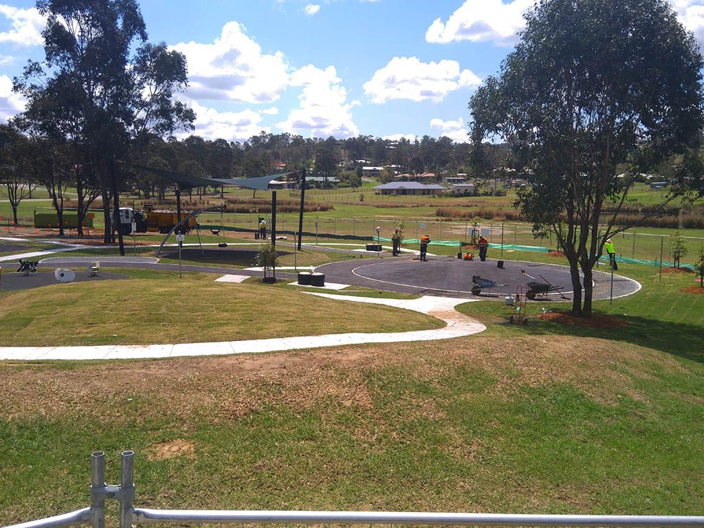 A view of a park with a playground in the background