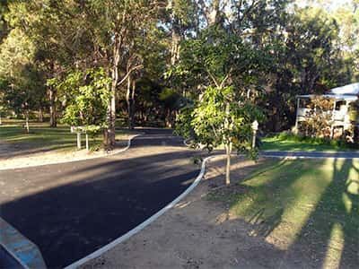 A yellow roller is rolling asphalt on a road.