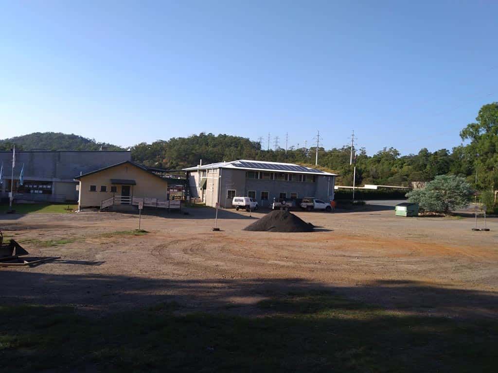A large dirt field with a building in the background