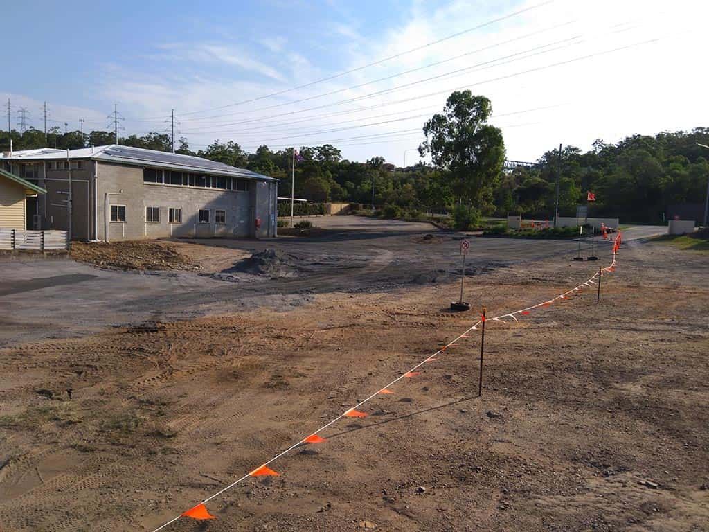 A large building is sitting in the middle of a dirt field.