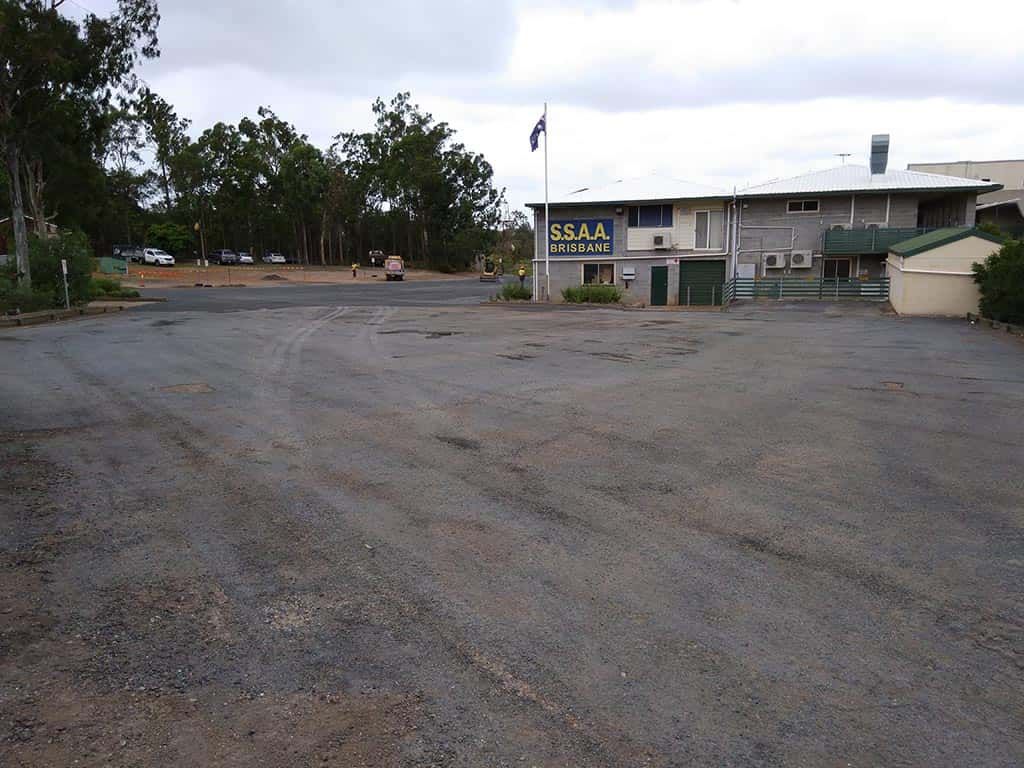 An empty parking lot in front of a building that says ' ssr ' on it