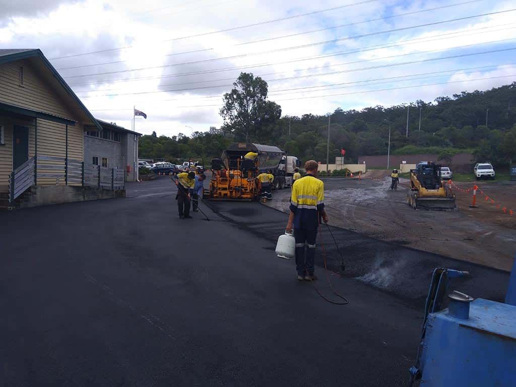 A group of construction workers are working on a road.