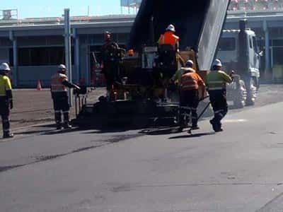 A group of construction workers are working on a road.