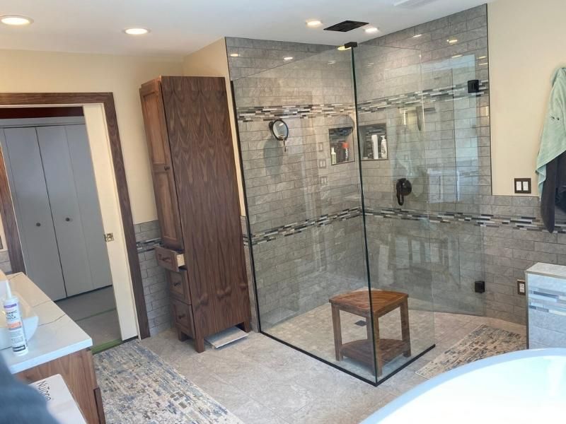 A bathroom with a walk in shower and a tub.