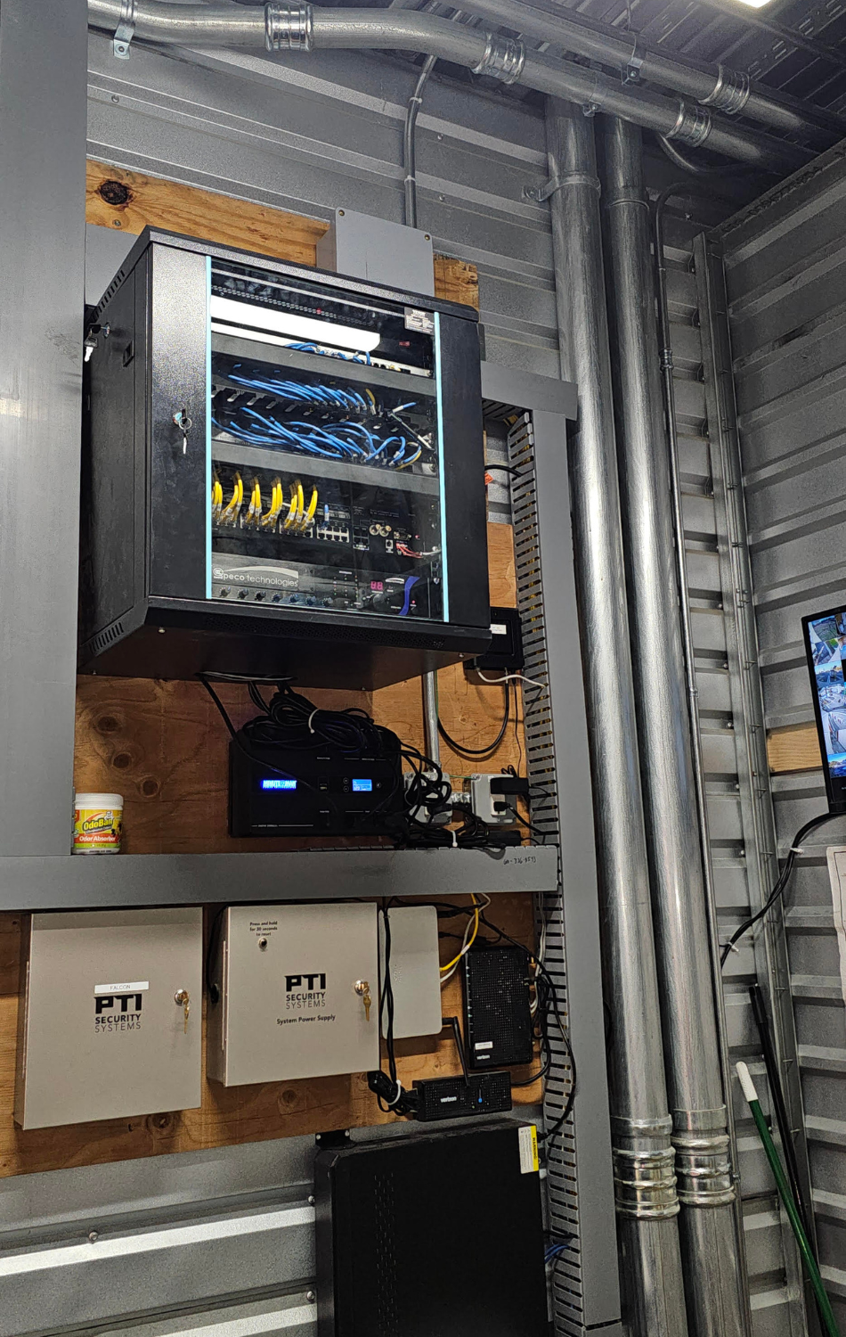 A computer server is hanging from the ceiling in a room.