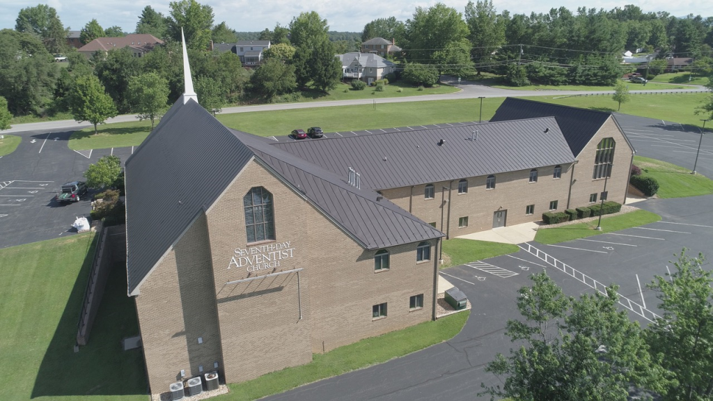 An aerial view of a church with a black roof